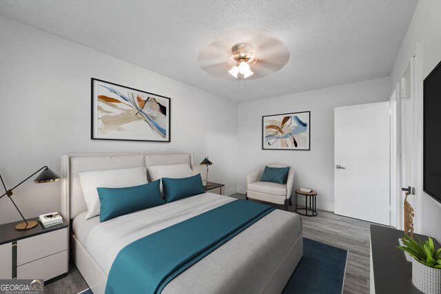 hall featuring a textured ceiling, wood finished floors, and baseboards