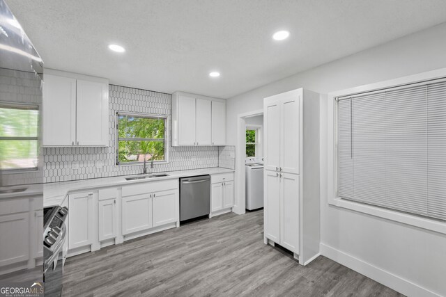 kitchen featuring stainless steel appliances, a sink, washer / dryer, backsplash, and recessed lighting