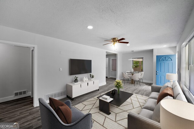 living area featuring ceiling fan, a textured ceiling, visible vents, wood finished floors, and recessed lighting