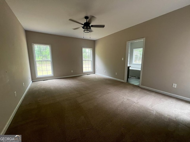 carpeted spare room with baseboards and ceiling fan