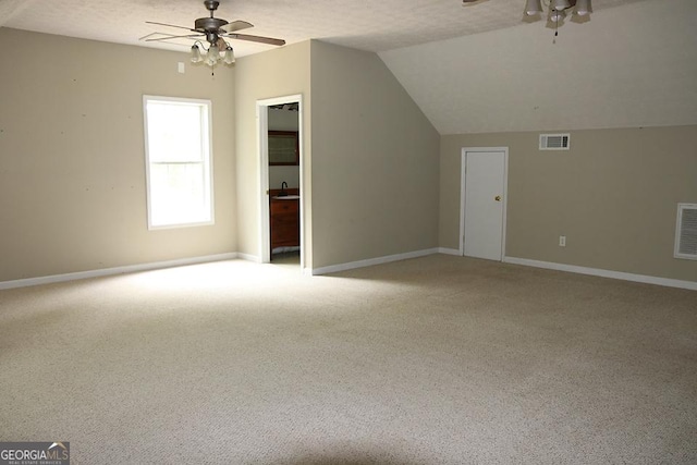additional living space with visible vents, a ceiling fan, vaulted ceiling, and light colored carpet