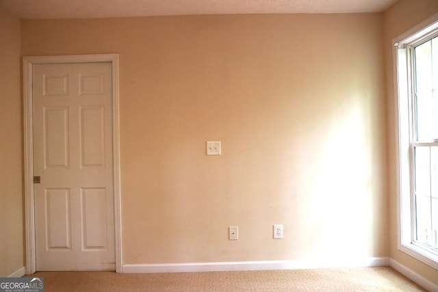 spare room featuring baseboards and carpet flooring