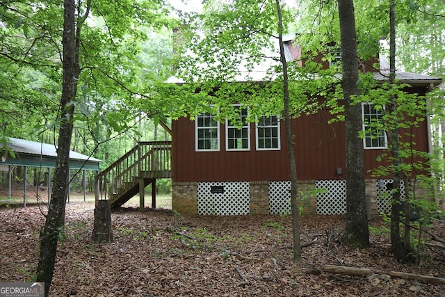 view of side of property featuring crawl space and stairs