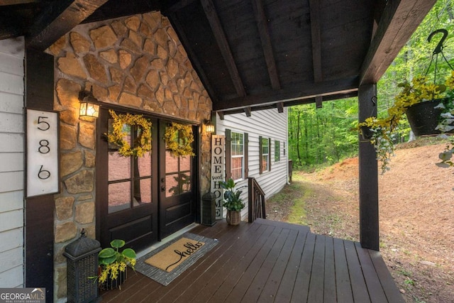 property entrance featuring a deck, french doors, and stone siding