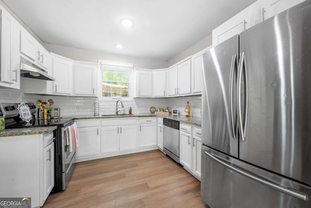 kitchen with light stone countertops, a sink, white cabinets, under cabinet range hood, and stainless steel appliances
