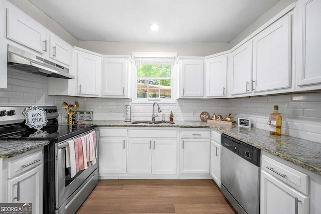 kitchen with a sink, appliances with stainless steel finishes, under cabinet range hood, and white cabinetry