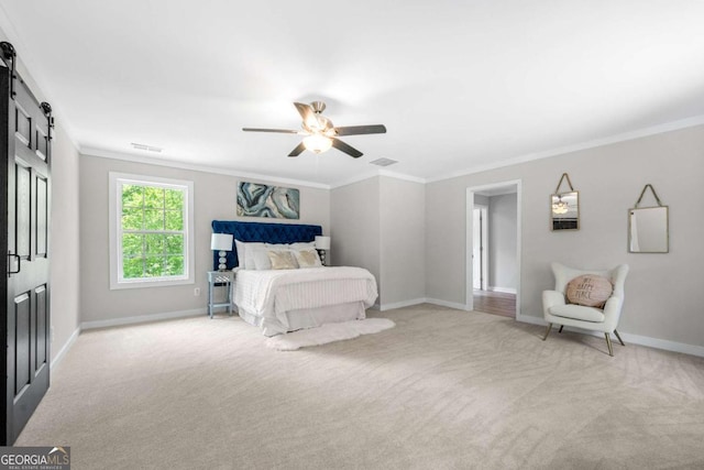 carpeted bedroom featuring baseboards, ceiling fan, a barn door, and ornamental molding