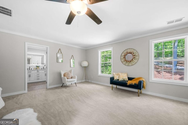 living area featuring visible vents, carpet, crown molding, and baseboards