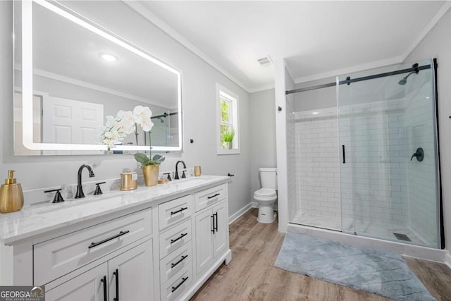 bathroom featuring a sink, toilet, visible vents, ornamental molding, and a stall shower