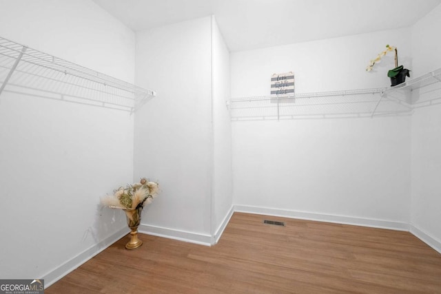 walk in closet featuring wood finished floors and visible vents