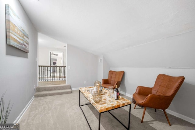 living area with baseboards, carpet, and vaulted ceiling