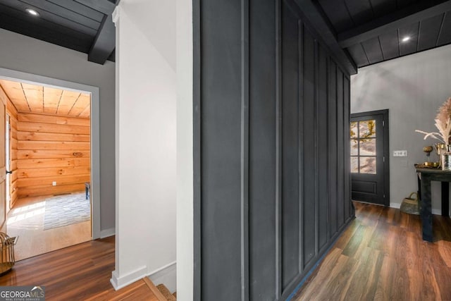 hall featuring recessed lighting, baseboards, dark wood finished floors, and wooden walls