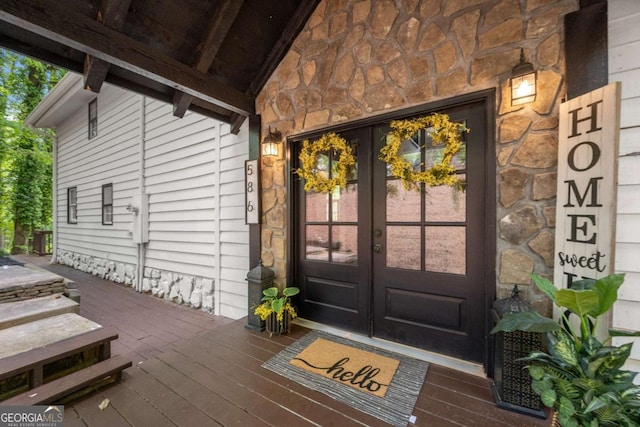 property entrance featuring french doors and stone siding