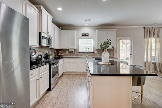 5601 Savannah River Rd, Atlanta, GA 30349 - kitchen with a sink, a breakfast bar, stainless steel appliances, and light wood-style flooring