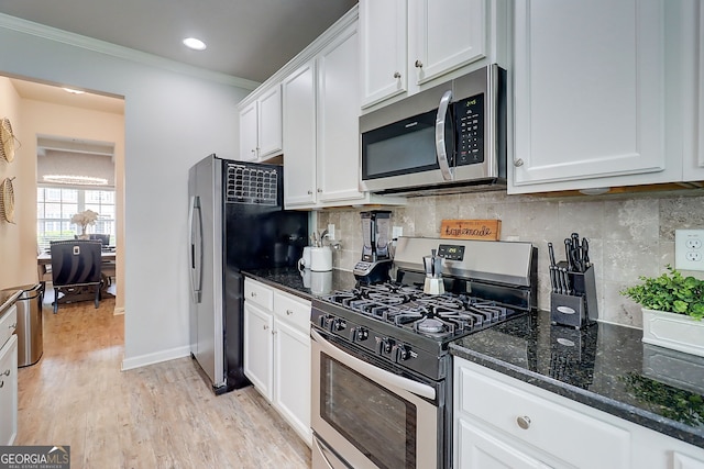 5601 Savannah River Rd, Atlanta, GA 30349 - kitchen with white cabinets, crown molding, appliances with stainless steel finishes, dark stone counters, and backsplash