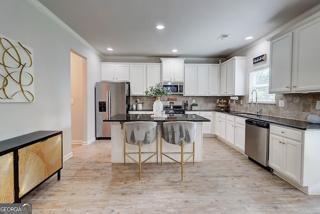 5601 Savannah River Rd, Atlanta, GA 30349 - kitchen with a kitchen island, visible vents, a sink, ornamental molding, and stainless steel appliances