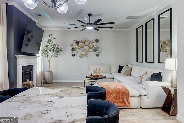 5601 Savannah River Rd, Atlanta, GA 30349 - living room featuring visible vents, ornamental molding, a glass covered fireplace, ceiling fan, and light wood finished floors