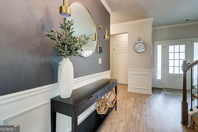 5601 Savannah River Rd, Atlanta, GA 30349 - foyer entrance featuring visible vents, crown molding, wood finished floors, a wainscoted wall, and stairs