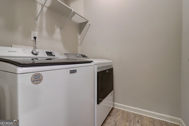 5601 Savannah River Rd, Atlanta, GA 30349 - clothes washing area featuring washing machine and clothes dryer, laundry area, baseboards, and light wood-style floors