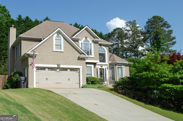 traditional-style home featuring a front lawn, a garage, stucco siding, a chimney, and concrete driveway