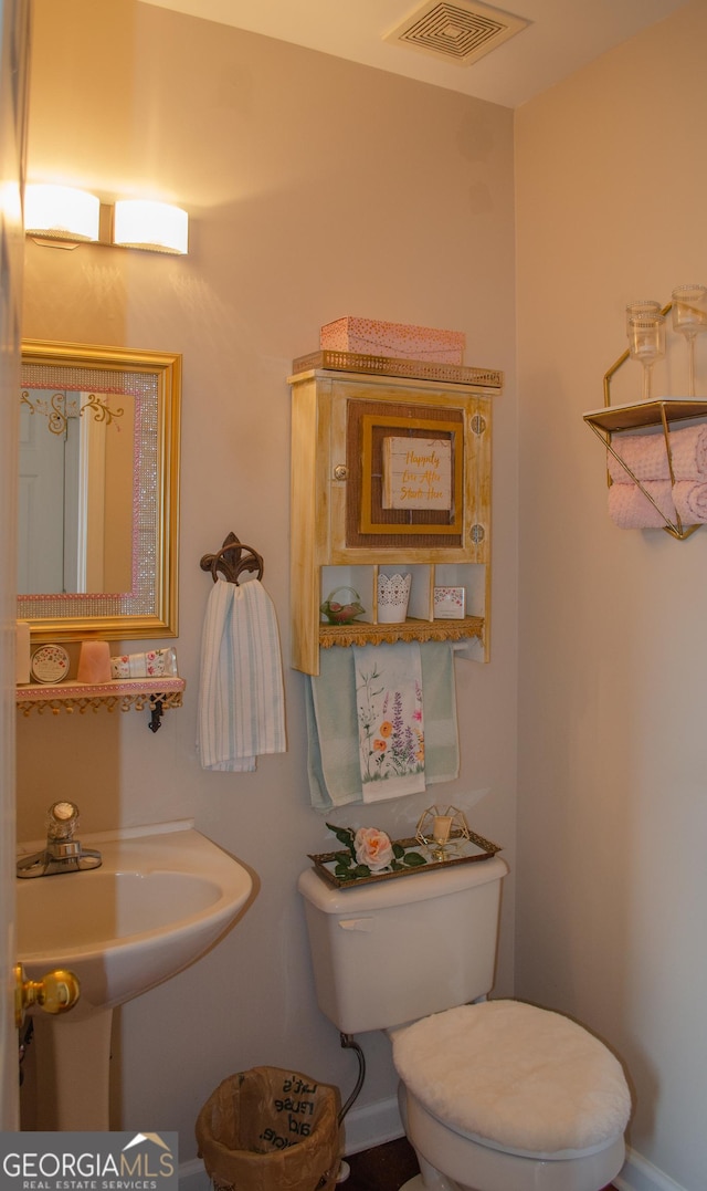 bathroom with toilet and visible vents