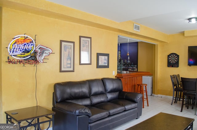 tiled living area with a dry bar and visible vents