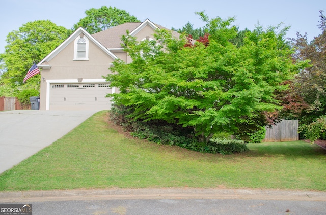view of front facade featuring fence, a front lawn, a garage, stucco siding, and concrete driveway