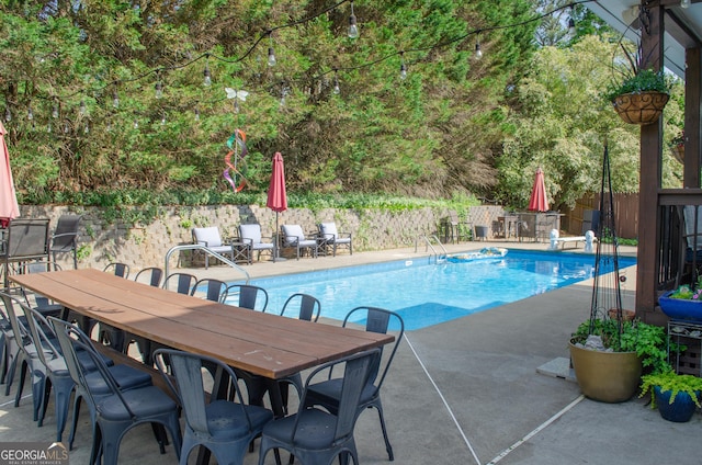 view of swimming pool featuring fence, a fenced in pool, outdoor dining area, and a patio area