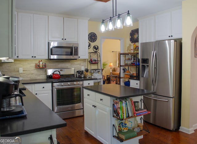 kitchen with backsplash, dark countertops, appliances with stainless steel finishes, dark wood finished floors, and white cabinets