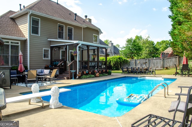 view of pool featuring a diving board, fence private yard, a patio area, a fenced in pool, and an outdoor hangout area