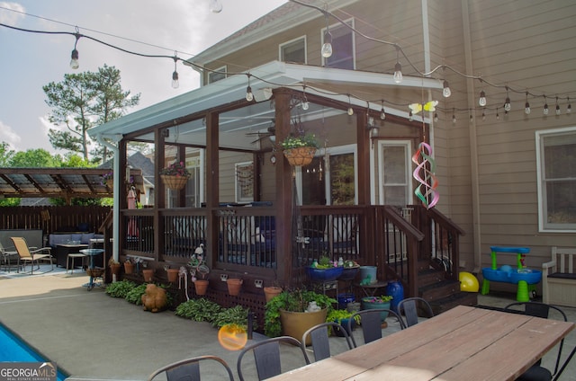 back of property with fence, outdoor dining space, and a patio area