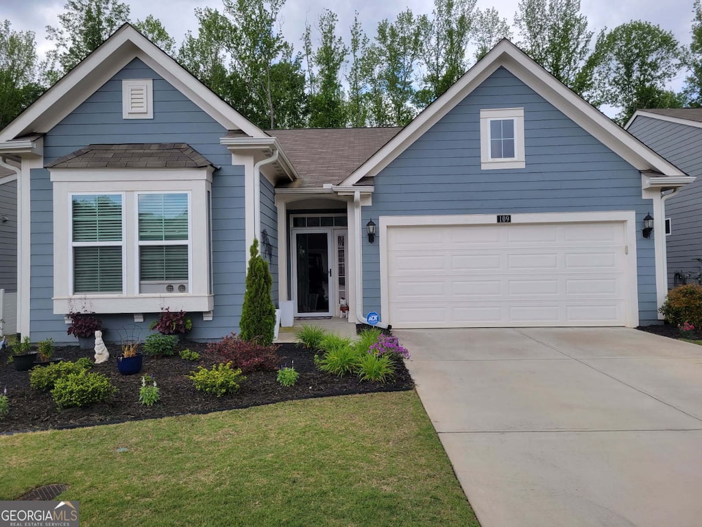 view of front facade with an attached garage, driveway, roof with shingles, and a front lawn