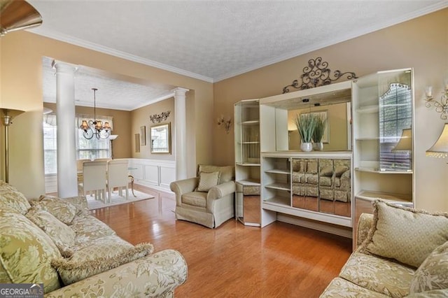 238 Diamond Valley Pass, Canton, GA 30114 - living room with an inviting chandelier, a textured ceiling, a wainscoted wall, wood finished floors, and ornate columns