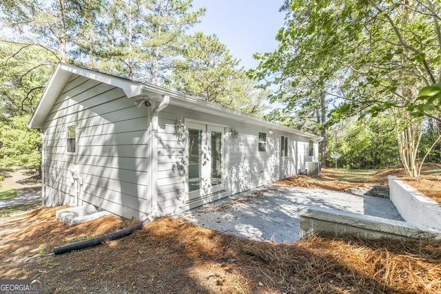 view of side of property featuring french doors, a patio, and central AC