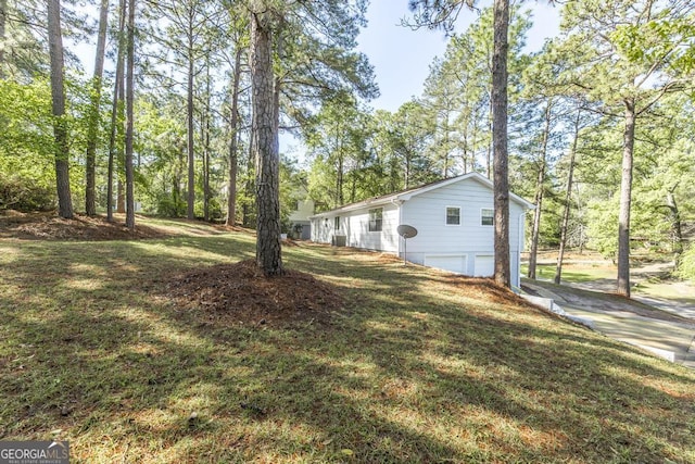 view of yard with a garage and driveway