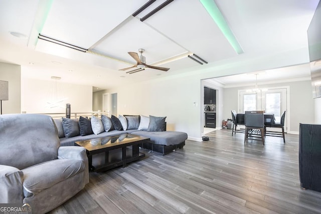 living room featuring baseboards, ornamental molding, a ceiling fan, and wood finished floors