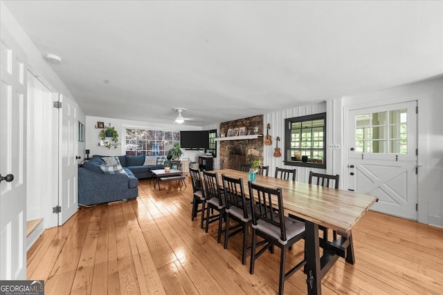 45 Michelle Cir NE, Atlanta, GA 30342 - dining area with light wood-style flooring, a stone fireplace, a ceiling fan, and healthy amount of natural light