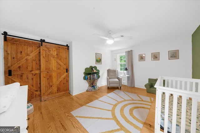 45 Michelle Cir NE, Atlanta, GA 30342 - bedroom featuring light wood finished floors, ceiling fan, baseboards, and a barn door