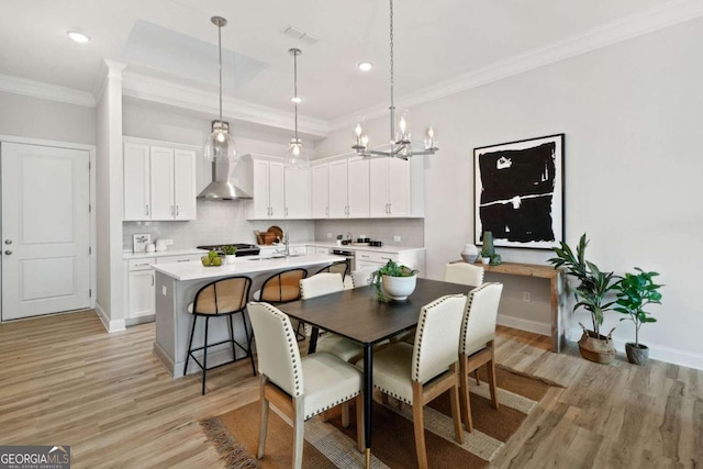 dining room featuring visible vents, ornamental molding, recessed lighting, light wood-style flooring, and a notable chandelier