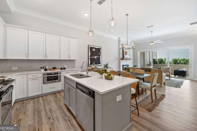 kitchen featuring a sink, appliances with stainless steel finishes, crown molding, and decorative backsplash
