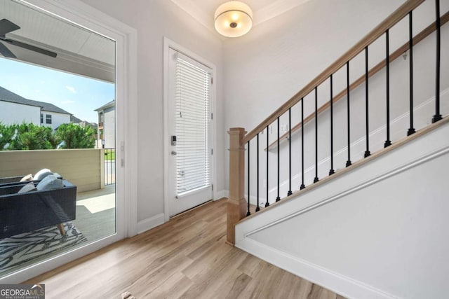 foyer featuring stairs, baseboards, a wealth of natural light, and wood finished floors