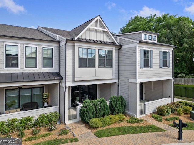multi unit property featuring fence, metal roof, and a standing seam roof