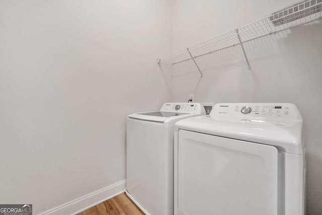 laundry room with laundry area, light wood-style flooring, baseboards, and washer and dryer