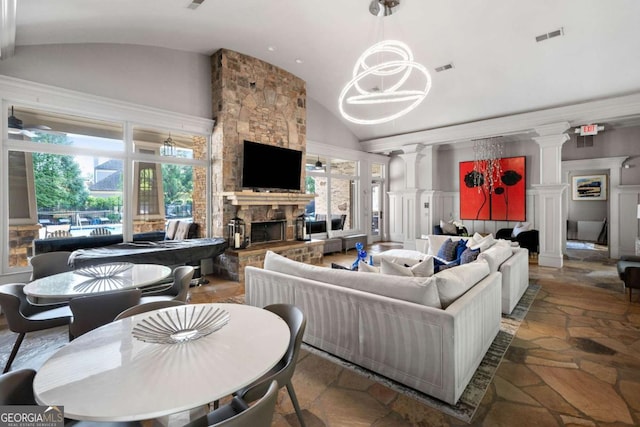 living area featuring stone tile flooring, visible vents, a fireplace, high vaulted ceiling, and ornate columns