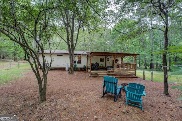 rear view of house with a wooden deck and fence