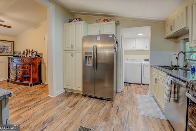 kitchen with a sink, separate washer and dryer, light wood-style flooring, stainless steel appliances, and lofted ceiling