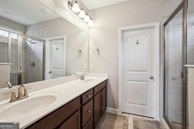 full bathroom featuring double vanity, a sink, a stall shower, and tile patterned floors
