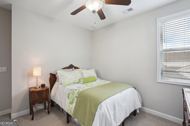 carpeted bedroom with visible vents, baseboards, and ceiling fan