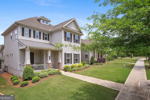view of front facade featuring covered porch, a standing seam roof, metal roof, a front yard, and a shingled roof