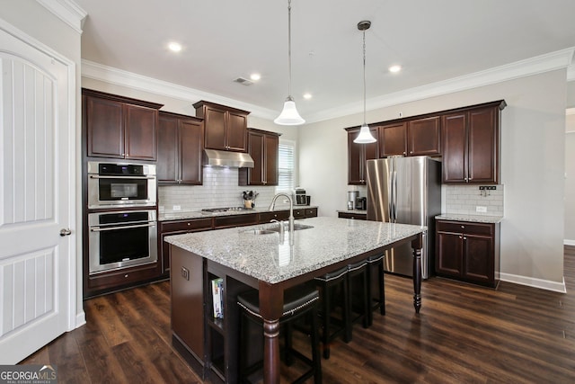 kitchen featuring dark brown cabinetry, a sink, stainless steel appliances, backsplash, and under cabinet range hood